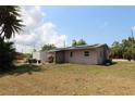 Exterior view of house with solar panels, motorcycle parked nearby, and green grass at 28024 Cleveland Ave, Punta Gorda, FL 33982