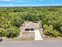 Aerial view of a home nestled among lush greenery, showcasing its spacious lot and peaceful setting at 3322 Hampton St, Port Charlotte, FL 33948