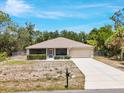 Well-maintained single-story house with a large driveway, a two-car garage, and a beautiful lawn at 3322 Hampton St, Port Charlotte, FL 33948