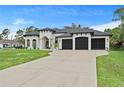 Stunning home with a three-car garage, lush lawn, and circular driveway at 3393 S Haberland Blvd, North Port, FL 34288