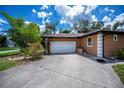 Spacious two-car garage with a concrete driveway, beautiful landscaping, and great curb appeal at 3960 Magara Ter, North Port, FL 34287