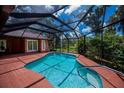 Screened-in pool with brick deck, view of lush landscaping and open sky at 3960 Magara Ter, North Port, FL 34287