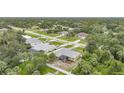 An aerial view showcases this home nestled among lush greenery and neighboring houses at 4413 S San Mateo Dr, North Port, FL 34288