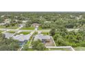 An elevated view showcases the home with its screened-in porch surrounded by verdant trees and greenery at 4413 S San Mateo Dr, North Port, FL 34288