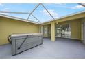 Covered outdoor patio featuring a hot tub and sliding glass doors leading to the interior at 4413 S San Mateo Dr, North Port, FL 34288
