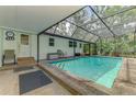 Screened-in pool area featuring a sparkling pool, with ample seating, and a covered space for relaxing at 4511 Wilkinson Rd, Sarasota, FL 34233