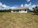 Expansive backyard featuring a pristine lawn, bright blue sky, and a blank canvas for outdoor enjoyment at 9469 Spring Cir, Port Charlotte, FL 33981