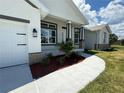 Inviting exterior elevation showcasing a manicured lawn, elegant stone accents, and a welcoming front porch at 9469 Spring Cir, Port Charlotte, FL 33981