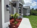 Inviting front entrance with a well-manicured lawn and decorative landscaping at 10023 Greetings St, Port Charlotte, FL 33981