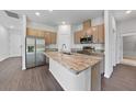 The kitchen featuring stainless steel appliances, a center island, and wood cabinetry at 1057 Presque Isle Dr, Port Charlotte, FL 33952