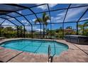 Relaxing screened-in pool area featuring a private hot tub and sunny skies at 13471 Chenille Dr, Port Charlotte, FL 33981