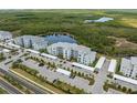 An aerial view showcasing a modern condo complex surrounded by lush greenery and tranquil lakes at 14141 Heritage Landing Blvd # 912, Punta Gorda, FL 33955