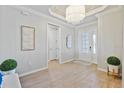 Elegant foyer featuring hardwood floors, a chandelier, and a front door with glass panels at 15039 Black Cherry Way, Punta Gorda, FL 33955
