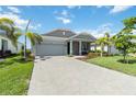 Charming single-story home showcases a two-car garage, paver driveway, and meticulously manicured lawn at 16824 Canopy Garden Dr, Port Charlotte, FL 33953