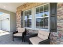 Inviting front porch with comfortable seating and brick accents at 16824 Canopy Garden Dr, Port Charlotte, FL 33953