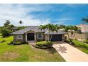 Charming single-story home with a well-manicured lawn and lush tropical landscaping at 17150 Sarong Ln, Punta Gorda, FL 33955