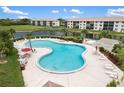 Relaxing kidney-shaped pool and jacuzzi, surrounded by lounge chairs and lush greenery at 175 Kings Hwy # 625, Punta Gorda, FL 33983
