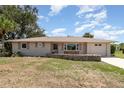 Charming single-story home with a well-maintained lawn and rock border under a blue sky at 18178 Wolbrette Cir, Port Charlotte, FL 33948