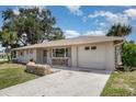 Well-maintained single-story home with a large driveway and attached garage on a sunny day at 18178 Wolbrette Cir, Port Charlotte, FL 33948