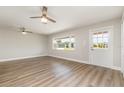 Living room featuring hardwood flooring, natural light, and modern ceiling fans at 18178 Wolbrette Cir, Port Charlotte, FL 33948