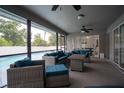 Relaxing screened-in patio with comfortable seating and ceiling fans, overlooking a sparkling pool at 21220 Pemberton Ave, Port Charlotte, FL 33952