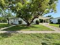 Inviting home with a well-manicured lawn and mature trees offering ample shade at 21899 Cellini Ave, Port Charlotte, FL 33952