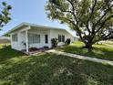 Well-maintained single-story house featuring a lush lawn and inviting entrance at 21899 Cellini Ave, Port Charlotte, FL 33952