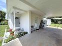 Covered carport featuring a bench, various potted plants, and direct access to a shed and the front door at 22334 Augusta Ave, Port Charlotte, FL 33952