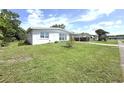 Quaint single-story home featuring a well-kept lawn, bright exterior, and a convenient carport at 22334 Augusta Ave, Port Charlotte, FL 33952