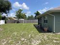 Large, grassy backyard with a wood fence and some trees at 2443 Lake View Blvd, Port Charlotte, FL 33948