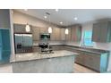 Well-equipped kitchen with stainless steel appliances, granite countertops, a kitchen island, and ample cabinet space at 2451 Waller Rd, North Port, FL 34288