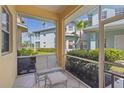 Cozy screened porch with outdoor seating and scenic views of palm trees and neighboring townhomes at 25555 Heritage Lake Blvd # 27, Punta Gorda, FL 33983