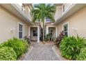Beautiful front entrance with brick pavers, a central palm tree, and symmetrical landscaping on either side at 2630 Tarpon Cove Dr # 212, Punta Gorda, FL 33950