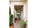 Cozy front porch with brick pavers, potted plants, and a hanging lantern, creating a welcoming entrance at 2630 Tarpon Cove Dr # 212, Punta Gorda, FL 33950