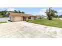Single-story home with a well-maintained lawn, a long driveway, and an attached garage at 3242 Nocturne Rd, Venice, FL 34293