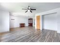 Spacious living room featuring modern laminate floors, a ceiling fan, and neutral wall paint at 3242 Nocturne Rd, Venice, FL 34293