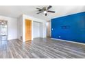 Open-concept living room with updated floors, a modern ceiling fan, and a bold accent wall at 3242 Nocturne Rd, Venice, FL 34293