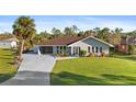 Charming single-story home with mature landscaping, a large front yard, and long driveway at 372 Cory St, Port Charlotte, FL 33953