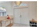 Bright entryway with double doors, tiled floor, decorative statue, and stylish furnishings enhance the home's character at 421 Strasburg Dr, Port Charlotte, FL 33954