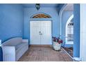 Inviting entryway featuring double doors, brick flooring, and a cozy bench, creating a warm welcome at 421 Strasburg Dr, Port Charlotte, FL 33954