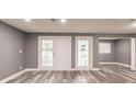 An open living room features grey walls, wood-look flooring, and double doors at 4371 Guard St, Punta Gorda, FL 33980
