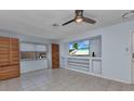 Inviting living room featuring built-in shelving, a ceiling fan, and tile floors at 4509 Wynkoop Cir, Port Charlotte, FL 33948