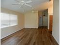 Spacious living room featuring wood floors, neutral paint, bright light through the window and dual ceiling fans at 500 Winwood Ct, Port Charlotte, FL 33954