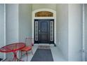 Inviting front entrance features a stylish black door with sidelights, a transom window and a cute red table setting at 591 San Ambrosio St, Punta Gorda, FL 33983