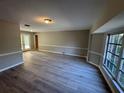 Spacious living room featuring new gray laminate flooring, white molding, and bright bay windows at 726 Chevy Chase St, Port Charlotte, FL 33948