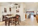 Cozy dining room featuring tile floors, a ceiling fan, and seating for four around a dark wood table at 7280 Muncey Rd, North Port, FL 34291
