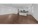 Bright living space featuring an open floorplan, wood-look floors, recessed lighting, and easy kitchen access at 7345 Ellis Ln, Port Charlotte, FL 33981