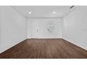 Bright, empty room features neutral walls, a window, and wood-look floors, awaiting personalization at 7345 Ellis Ln, Port Charlotte, FL 33981