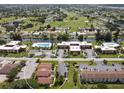 Aerial view of a condo community with mature trees, parking, and a community pool at 93 Boundary Blvd # 303, Rotonda West, FL 33947