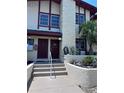 Close up of condo entrance with decorative landscaping, steps, and two entry doors at 93 Boundary Blvd # 303, Rotonda West, FL 33947